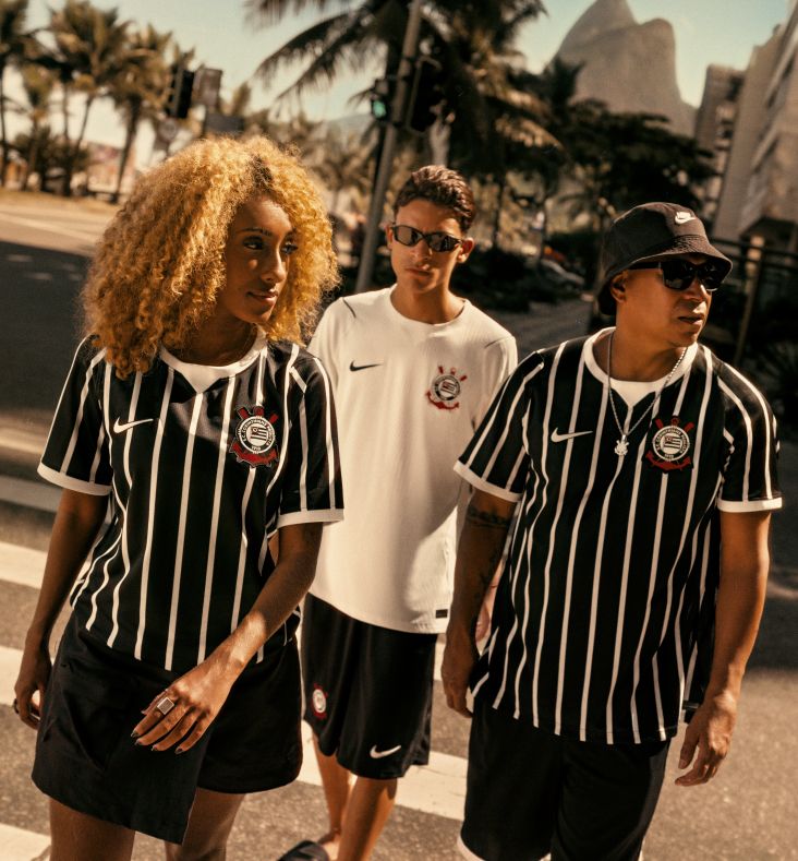 Três pessoas andando usando a nova coleção do Corinthians 50 Anos