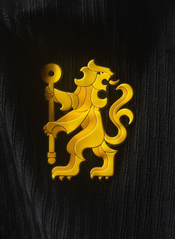 Camisa de fora do Chelsea focando na gola e escudo, preta com detalhes em dourado