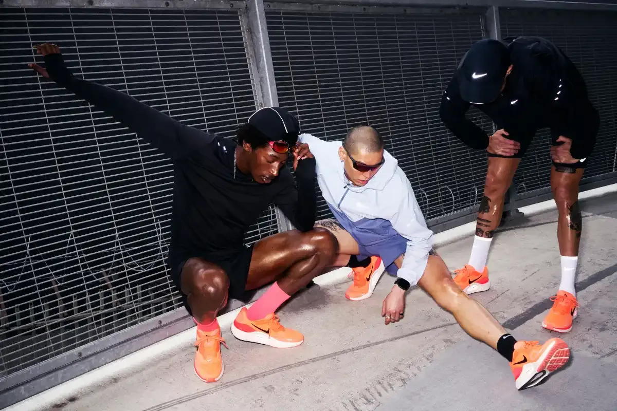 Atletas praticando alongamento na rua, com foco em corrida e treinamento esportivo, usando roupas esportivas e tênis de corrida. 