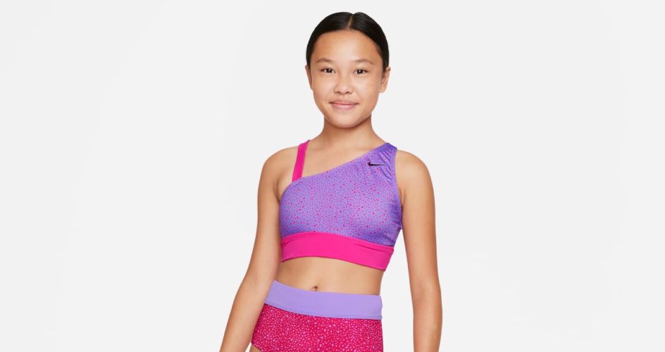 Menina com conjunto de natação rosa e lilás da Nike.