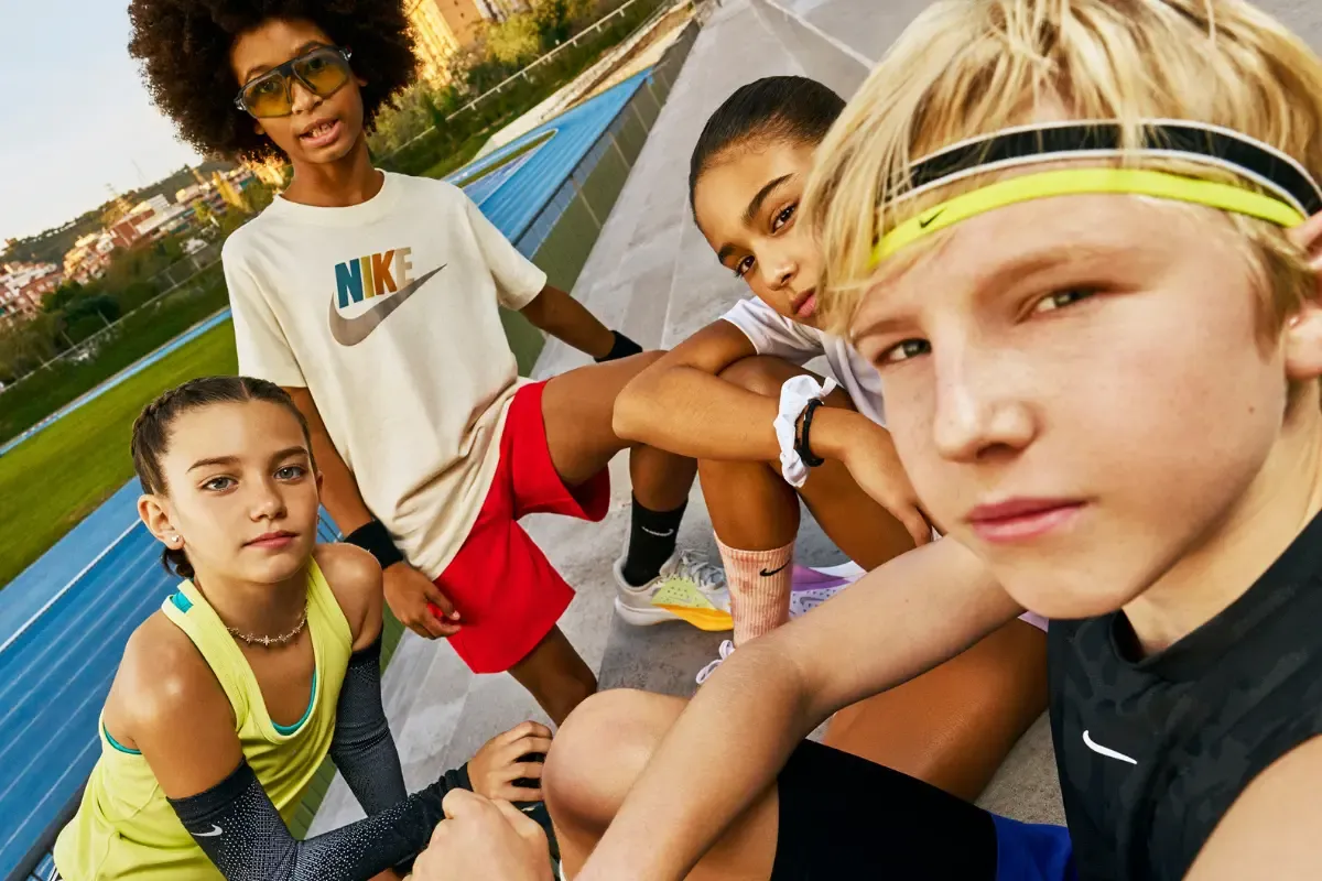 quatro crianças com roupa esportiva em um campo de futebol