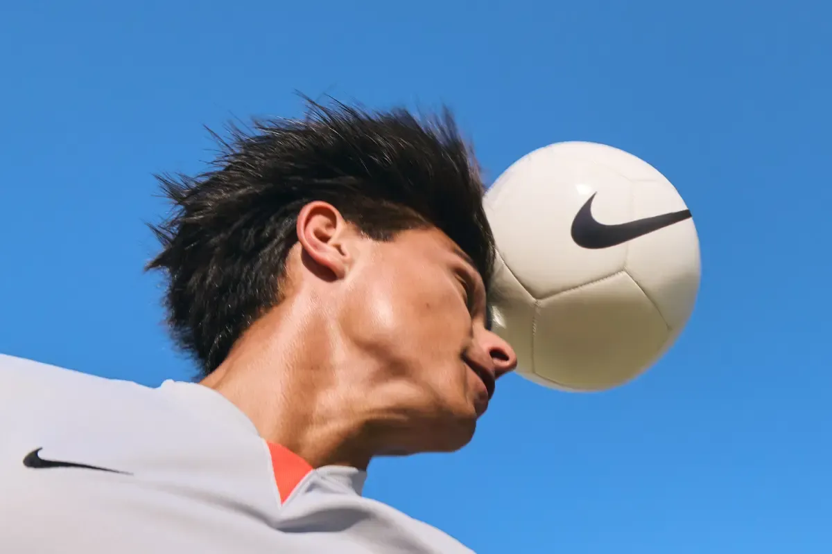 homem com uma bola na cabeça jogando futebol