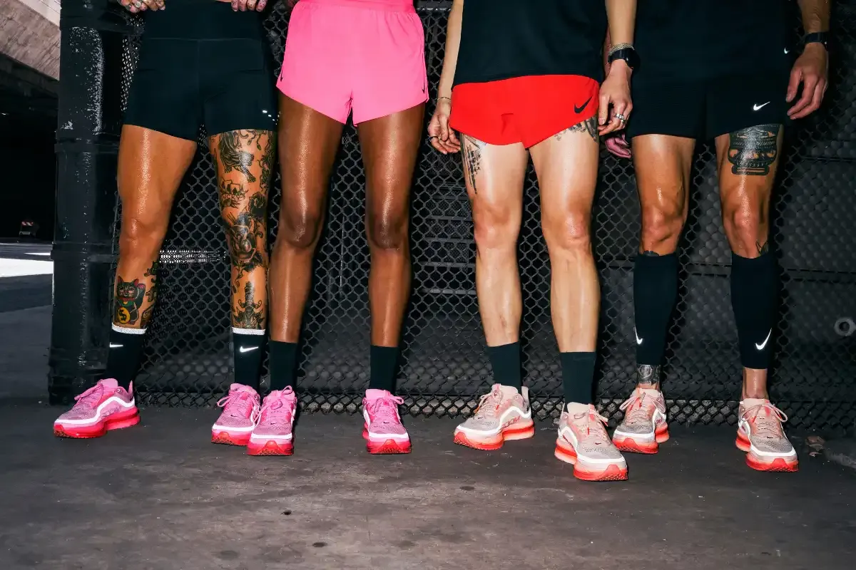 Grupo com roupas esportivas e tênis de corrida em uma academia, exibindo força e determinação em atividades físicas.