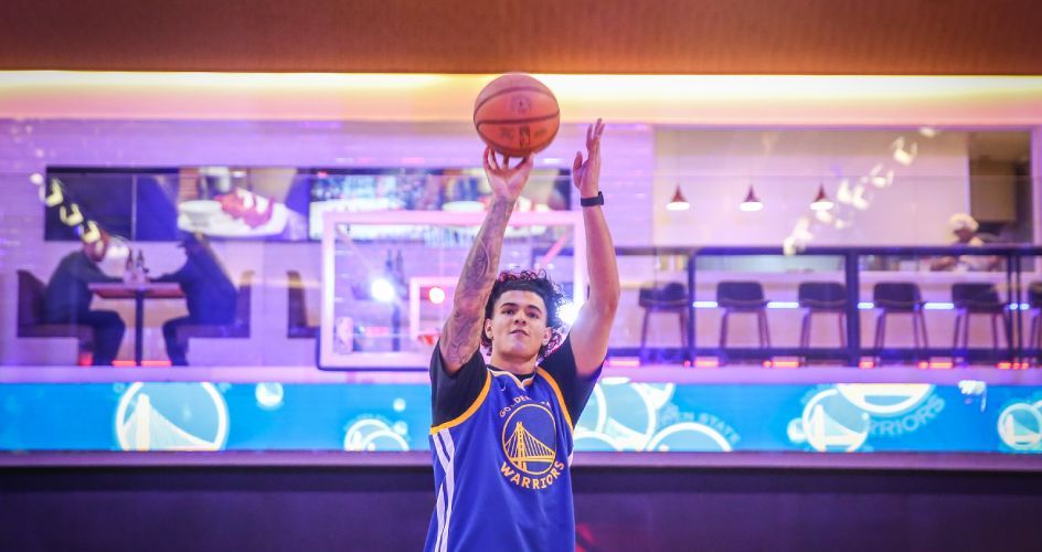 Gui Santos lançando a bola de basquete.