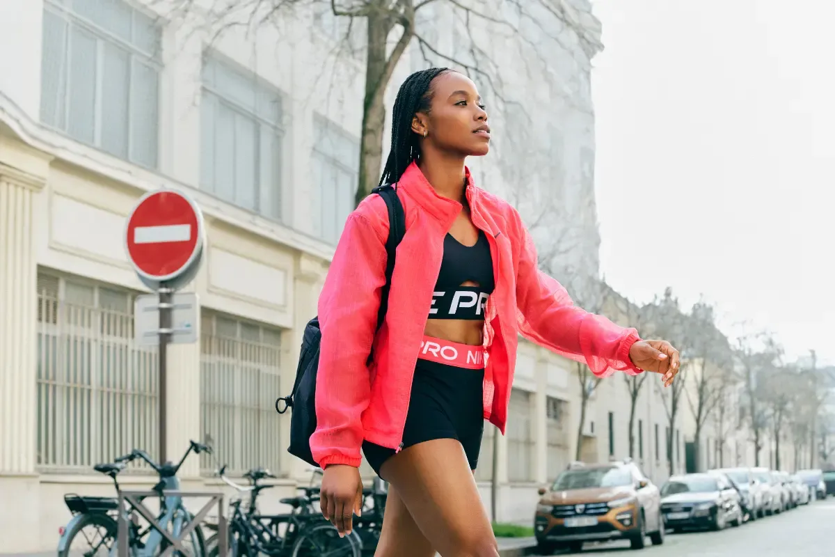 mulher com roupa de academia com mochila na rua