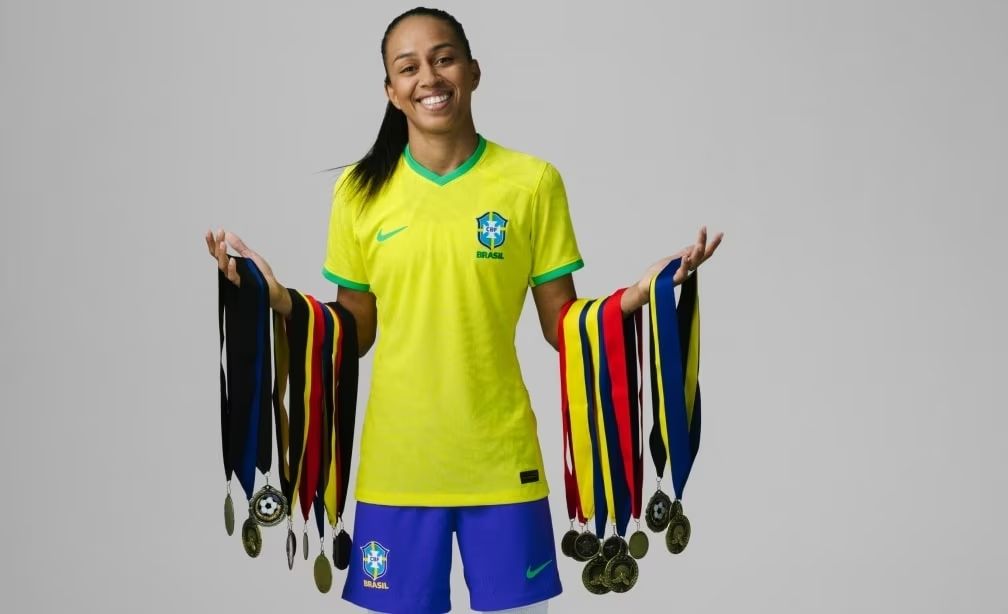 Adriana Silva segurando suas medalhas nos dois braços esticados para as laterais do corpo.